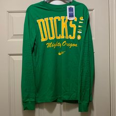 Brand New And Never Worn Nike University Of Oregon Ducks Football Long Sleeve T-Shirt In A Size Medium. Nike Collegiate Long Sleeve T-shirt, Nike Green Graphic Print T-shirt, Green Pre-shrunk Tops For Spring, Nike Long Sleeve Cotton T-shirt, Long Sleeve T-shirt With Logo Print For Game Day, Nike Long Sleeve T-shirt For Spring, Fan Apparel Long Sleeve Top With Logo Print, Long Sleeve Logo Print Fan Apparel Top, Long Sleeve Fan Apparel Top With Logo Print