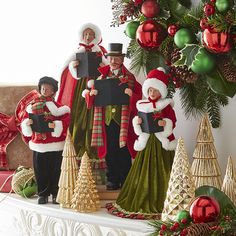 three christmas figurines are standing on a mantel