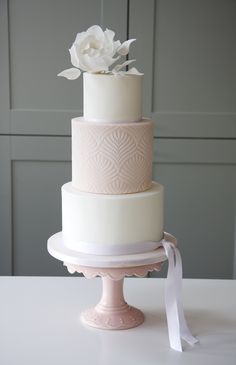 a three tiered cake with white flowers on top