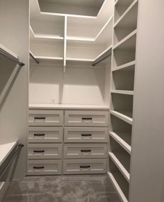 an empty walk in closet with drawers and shelves