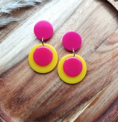 Introducing these fabulous retro drop earrings! Inspired by Pop Art designs from the 1960s, these colour block earrings are sure to make a statement. Handmade in bright pink and yellow resin, these colourful earrings are crafted to create a sleek and modern look. The geometric design adds a touch of sophistication, while the bold design adds a pop of contrast. Perfect for any occasion, these unique earrings are a must-have accessory for those who love to embrace retro vibes with a modern twist. Retro Multicolor Drop Earrings, Retro Yellow Dangle Earrings, Retro Handmade Drop Earrings, Retro Pink Drop Earrings, Handmade Retro Pink Earrings, Retro Yellow Earrings For Party, Retro Handmade Earrings For Party, Retro Multicolor Jewelry With Matching Earrings, Handmade Retro Earrings For Party