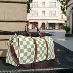 "Travel in Style with Our Green Checkered Pattern Weekend Duffel Bag - Your Perfect Getaway Companion! Embark on unforgettable weekend adventures with our Checkered Pattern Weekend Duffel Bag, a delightful blend of fashion and functionality that allows you to travel in style without compromising on practicality. Key Features: Chic and Vibrant Design: Our duffel bag features a chic and vibrant checker pattern that sets you apart from the crowd. The beautiful blooms add a touch of elegance to your travel ensemble, making it a statement piece that exudes charm. Spacious and Versatile: With a generous interior, this duffel bag offers ample space to pack your clothing, essentials, and travel necessities for a weekend getaway. It's the perfect companion for short trips or as a carry-on bag for l Trendy Rectangular Travel Bag For Outdoor, Green Travel Shoulder Bag Portable, Green Portable Shoulder Bag For Travel, Portable Green Shoulder Bag For Travel, Portable Green Travel Bag, Retro Outdoor Bags With Large Capacity, Large Capacity Retro Outdoor Bag, Retro Travel Bag With Large Capacity, Green Rectangular Duffle Bag For Travel