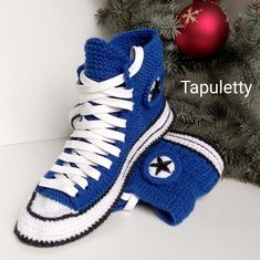 a pair of blue and white sneakers sitting next to a christmas tree with the word tapplety written on it