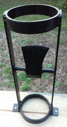 a black metal object sitting on top of a wooden table next to a grass field