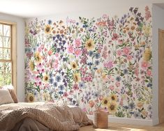 a bedroom with flowers painted on the wall next to a bed in front of a window