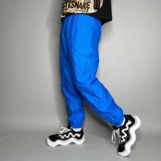 "Vintage Track Pants Royal Blue Nylon Joggers Elastic Cuffs has Ankle Zippers Lined Head 90s Skate / Streetwear Great Condition: 9/10 Men's Size: Medium My Hands in Pockets = It has Pockets No Hands in Pockets = Does Not Have Pockets Drawstring Will be Visible in Forward Pic, if not Visible it Does Not Have a Drawstring About me: I am 6' 0\" for reference I generally wear a Large (32\" inseam) I Model XS to 2XL sweatpants, I find that you can often size up or down with 95% of sweatpants and they fit the same" Sporty Blue Pants With Elastic Cuffs, Summer Streetwear Nylon Parachute Pants, Spring Nylon Streetwear Bottoms, Blue Hip Hop Pants For Spring, Retro Blue Bottoms For Streetwear, Nylon Bottoms For Spring Streetwear, 90s Style Baggy Blue Pants, 90s Style Blue Baggy Pants, Streetwear Nylon Bottoms With Elastic Cuffs