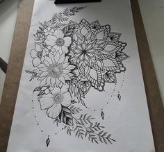 a piece of paper with flowers drawn on it and some pencils next to it