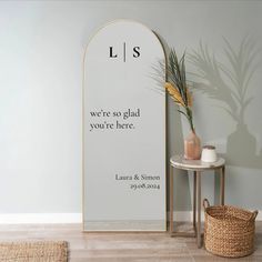 there is a vase with some plants in it next to a sign that says, lis we're so glad you're here