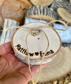 a hand holding a piece of wood with the words mathew eime written on it