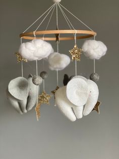 an elephant mobile with stars and clouds hanging from it