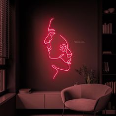 a red neon sign with a man's face on the wall next to a chair