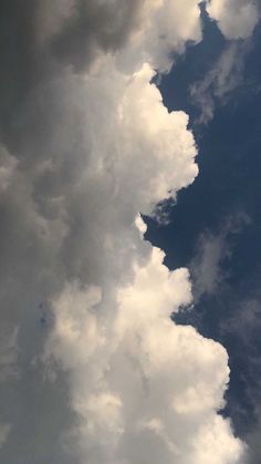 an airplane is flying through the cloudy sky