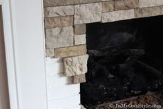 a fire place that is in the corner of a room with a brick fireplace and white walls