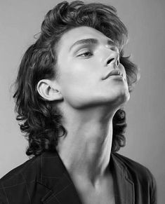 a black and white photo of a man with curly hair looking up to the sky