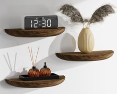 two wooden shelves with candles, vases and an alarm clock on the wall behind them