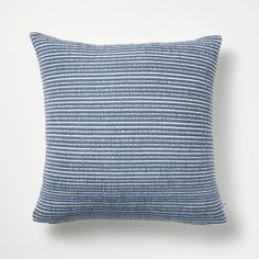 a blue and white striped pillow on a white wall