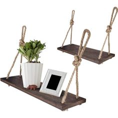 two wooden shelves with rope hanging from them and a potted plant on the shelf