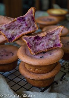 a person is holding some food in front of other muffins on a cooling rack