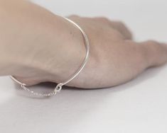 This minimalist bracelet cuff made of sterling silver wire. The chain that attached to the bracelet and lock is also sterling silver. Its edgy and minimalist style fits well with casual fashion. Perfect as a gift to a stylish girl or woman. If you like simplicity and minimalism, this piece is for you!Measurements: wire width 1.5 mm.<3 Please provide me with your size! I will need a circumference of your wrist. You can take a thread, wrap it around your wrist and measure the size on a ruler. You Minimalist Chain Bracelet With Sterling Silver Clasp, Sterling Silver Bracelet With Delicate Chain For Everyday, Delicate Chain Sterling Silver Bracelet For Everyday, Minimalist Sterling Silver Chain Bracelet, Everyday Sterling Silver Bracelet With Delicate Chain, Adjustable Sterling Silver Chain Bracelet Minimalist Style, Adjustable Sterling Silver Minimalist Chain Bracelet, Minimalist Sterling Silver Heart Bracelet, Minimalist Sterling Silver Bracelet