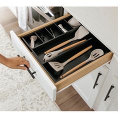 an open drawer with utensils in it