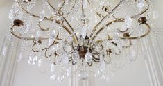 a chandelier hanging from the ceiling in a room with white walls and ceilings