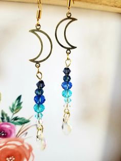 Crescent moon charms with dangly glass beads. Simple and elegant, these earrings are perfect for day or night! The perfect amount of sparkle when the sun hits just right! Handmade Celestial Crystal Earrings For Gift, Handmade Moon-shaped Spiritual Earrings, Handmade Spiritual Moon Earrings, Handmade Whimsical Moon Earrings, Whimsical Moon-shaped Handmade Earrings, Handmade Celestial Crystal Drop Earrings, Handmade Mystical Crystal Earrings As Gift, Handmade Crescent Crystal Earrings For Gift, Handmade Crescent Crystal Earrings As Gift