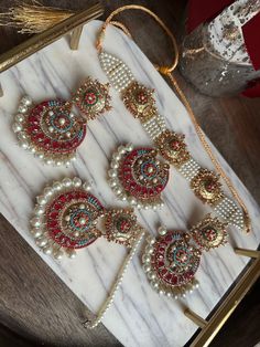 This elegant choker in the vintage nauratan style is perfect for wearing to engagement parties, valima, nikkah, mehndi ceremonies, and bridal showers. Nauratan, which translates to "nine colors" in Hindi and Urdu, is a well-liked traditional jewellery design that is frequently worn by Indian and Pakistani citizens. This jewellery set is embellished with tiny, nine pastel-colored beads on every piece. This set is elegantly presented in a sliding box that may be given as a gift. About this item: T Mehndi Jewellery Pakistani, Luxury Multicolor Meenakari Sets, Traditional Chandbalis With Stone Work For Reception, Traditional Stone Work Chandbalis For Reception, Bollywood Style Necklaces With Latkans For Wedding, Bollywood Style Necklace With Latkans For Wedding, Bollywood Necklaces With Latkans For Wedding, Kundan Necklace With Stone Work For Wedding And Eid, Red Stone Work Jewelry For Eid