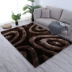 a living room area with a couch, rug and potted plant on the floor