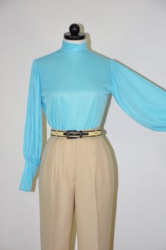 "Gorgeous vintage 1960s - 1970s turquoise blouse with high neckline, zipper back closure, long bishop sleeves with wide cuffs cuffs and slim fit. Super lightweight, soft and silky poly fabric, unlined, sheer. Original tags attached. M E A S U R E M E N T S  (taken flat, unstretched) size on tag: vintage 11-12 / please see measurements below for a perfect fit fits like: approx. XS / S bust (armpit to armpit): 19\" / 48m (x2) waist (at narrowest part): 18\" / 46cm (x2) back (left to right shoulder seam): 14\" / 35.5cm sleeve length (shoulder to cuff): 23\" / 58.5cm length (shoulder to hem): 23\" / 58.5cm fabric: 100% Celanese Fortrel polyester color: blue brand / maker: Cheeky Knits for Lady Manhattan condition: excellent vintage / original tags attached * * * * * * Additional TOPS & SHIRTS: Blue Fitted Blouse With Balloon Sleeves, Blue Fitted Top With Balloon Sleeves, Blue Fitted Top With Lantern Sleeves, Blue Fitted Lantern Sleeve Tops, Fitted Turquoise Long Sleeve Tops, Blue Bishop Sleeve Tops For Fall, Fitted Long Sleeve Light Blue Blouse, Fitted Blue Blouse With Blouson Sleeves, Turquoise Long Sleeve Blouse