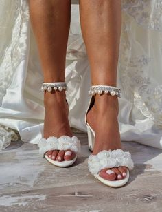 the bride's shoes are adorned with pearls