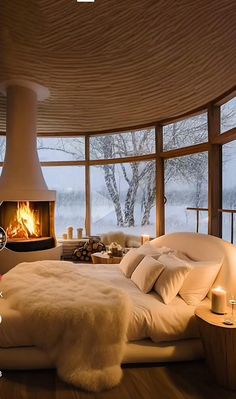 a bedroom with a fireplace in the corner and lots of pillows on the bed next to it