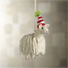 a white sheep ornament with a red and green hat on it's head