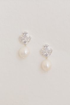 two pairs of pearl and crystal earrings on a white background with copy space for text