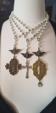 These Beautiful Religious Charm Necklaces are a great statement piece. These are on faux pearl link chain with brass lobster claw closure. I will list each one according to the pics, from left to right  *Each sold separately. If you need an longer chain size I can add some links just leave a note when ordering.  1. SAN MIGUEL ARC ANGEL. This is a Y style necklace with a brass angel charm and a brass San Miguel metal charm. These are faux pearl link chain and measures 17 inches long with brass lo Vintage Metal Necklace With Pearl Charm, Vintage Pearl Chain Necklace Gift, Vintage Pearl Chain Necklace For Gift, Vintage Pearl Chain Necklace As Gift, Arc Angel, Sales Ideas, Rosary Style Necklace, Metal Skull, Angel Charm