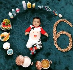 a little boy laying on the floor surrounded by food