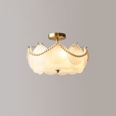 a ceiling light with three shells on it's sides and two lights in the middle