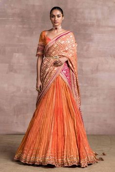 Bright orange crinkled lehenga paired with brocade blouse enhanced with embroidered sleeves. Comes with heavy georgette-brocade drape in ombre shades.
Component: 3
Embroidered
Neckline: V-neck
Sleeve Length: Half
Fabric: Blouse: Brocade, Dupatta: Handloom
Color: Orange
Bead tassels
Crush texture
Back tie-up
Note: Belt worn by the model is not for sale - Aza Fashions Chanderi Lehenga, Sari Lehenga, Orange Lehenga, Half Saree Lehenga, Brocade Blouse, Gaun Fashion, Brocade Blouses, Half Saree Designs, Tarun Tahiliani