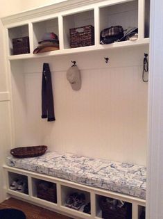 a white coat rack with shoes and hats on it next to an entryway bench