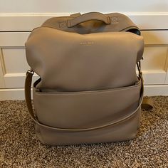 This Diaper Bag Was An Absolute Dream. So Many Pockets, Plenty Of Space And You Can Wear It As A Backpack Or On The Shoulder. It Is Used But Still In Great Condition! There Is Some Slight Cracking On The Top Handle Which I Included A Picture Of. It’s In The Color Sand. Luxury Large Capacity Backpack For Errands, Leather Backpack With Large Capacity For Errands, Daily Satchel Backpack With Detachable Strap, Everyday Satchel Backpack With Detachable Strap, Everyday Backpack With Detachable Strap And Double Handle, Daily Leather Backpack With Detachable Strap And Double Handle, Leather Large Capacity Backpack For Errands, Everyday Standard Backpack With Removable Pouch, Daily Backpack With Removable Pouch