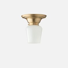 a light fixture with a white glass shade on it's face and gold trim