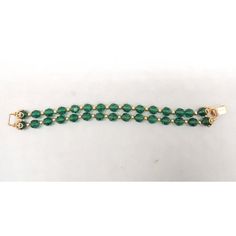 This is part of Chairish’s Costume Jewelry assortment.  Goldtone two strand cut green glass beads with round goldtone smaller spacer beads and filigree details near the fold over clasp. Marked "Napier." Measures: 7 5/8 inches long by 3/4 inches wide. Excellent condition. An identical bracelet except with red glass beads is shown on pg. 370 of Melinda L. Lewis & Henry Swen's book "The Napier Co.: Defining 20th Century American Costume Jewelry." Dates to 1963. Formal Single Strand Beaded Bracelet With Round Beads, Elegant Green Beaded Bracelets For Formal Events, Elegant Green Beaded Bracelets For Formal Occasions, Elegant Double Strand Spacer Beads, Gold Double Strand Faceted Beads Bracelets, Gold Double Strand Beaded Bracelets With Faceted Beads, Elegant Green Beaded Bracelets For Festive Occasions, Elegant Single Strand Green Beads, Elegant Green Single Strand Beads