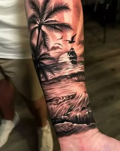 a man's arm with a palm tree and ship in the ocean on it