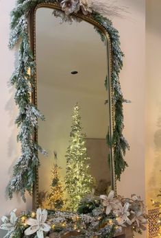 a mirror sitting on top of a mantle next to a christmas tree