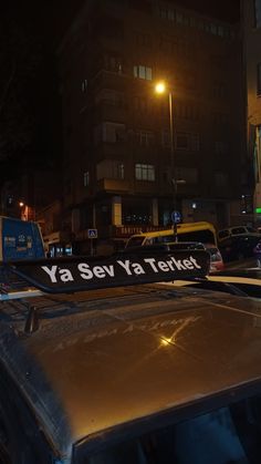 an old car is parked on the side of the street at night with a sign that says ya sey ya tektey