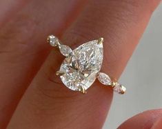 a woman's hand with a diamond ring on it