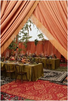 a dining table set up in an orange and green tent for a wedding or party