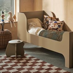 a child's bed in a bedroom with toys on the floor and window sill