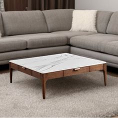 a marble top coffee table sitting in front of a couch