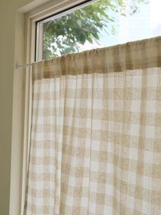 a window with a checkered curtain hanging from it's side