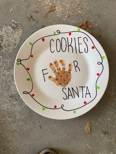 a plate with a handprint on it that says cookies for santa